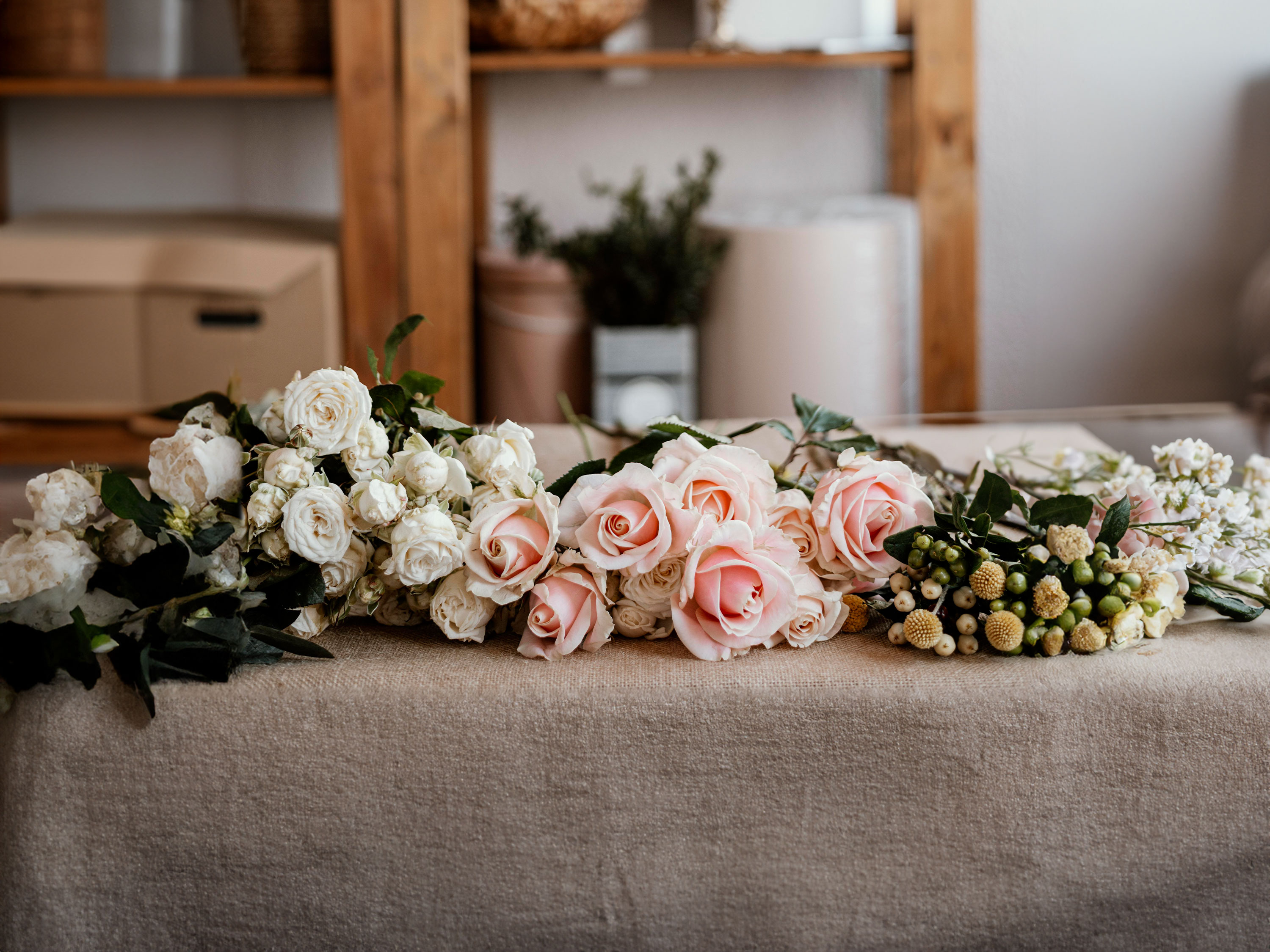 Wedding florals laid on a covered table.