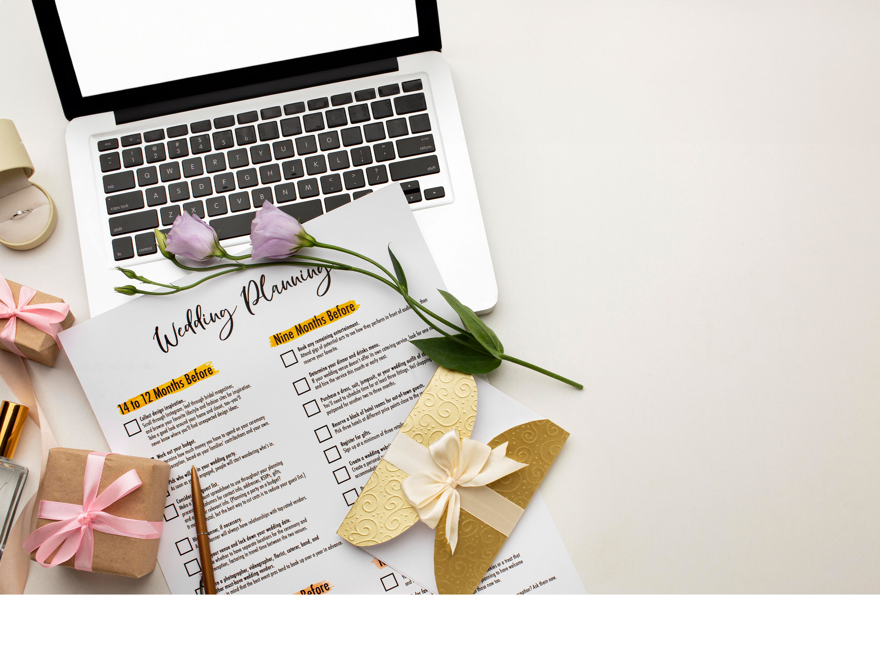 A wedding planning sheet laid on a table with a laptop and wedding decorations.
