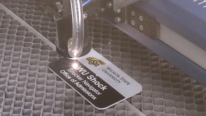 A faculty badge being lasered in the engraving machine.