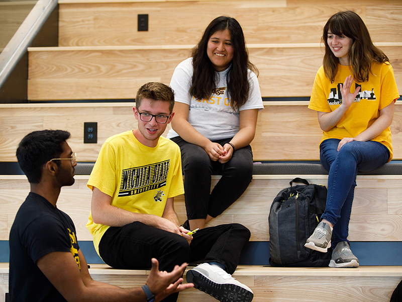 Student models pose for a photo on the social stair inside Woolsey Hall
