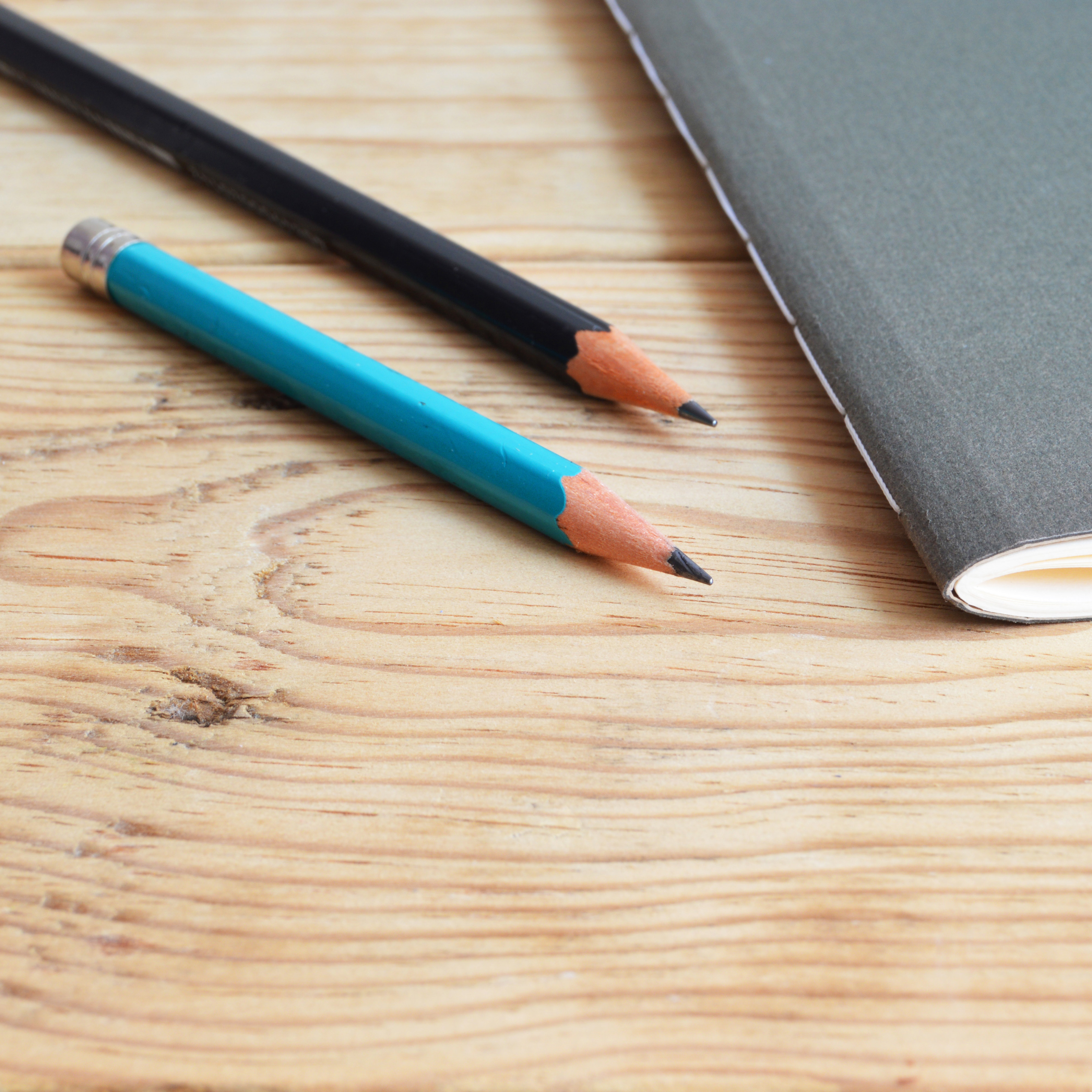 Two pencils and an exam book on a desk
