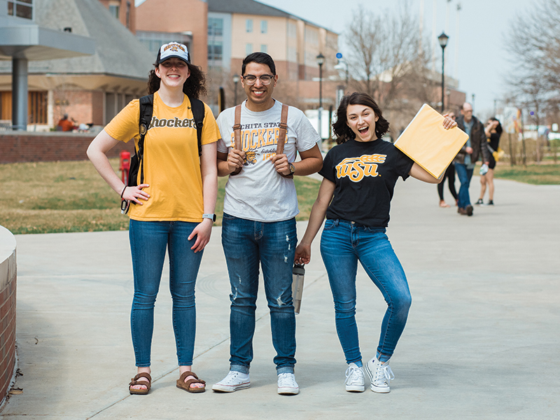 Three students posing outside the RSC.