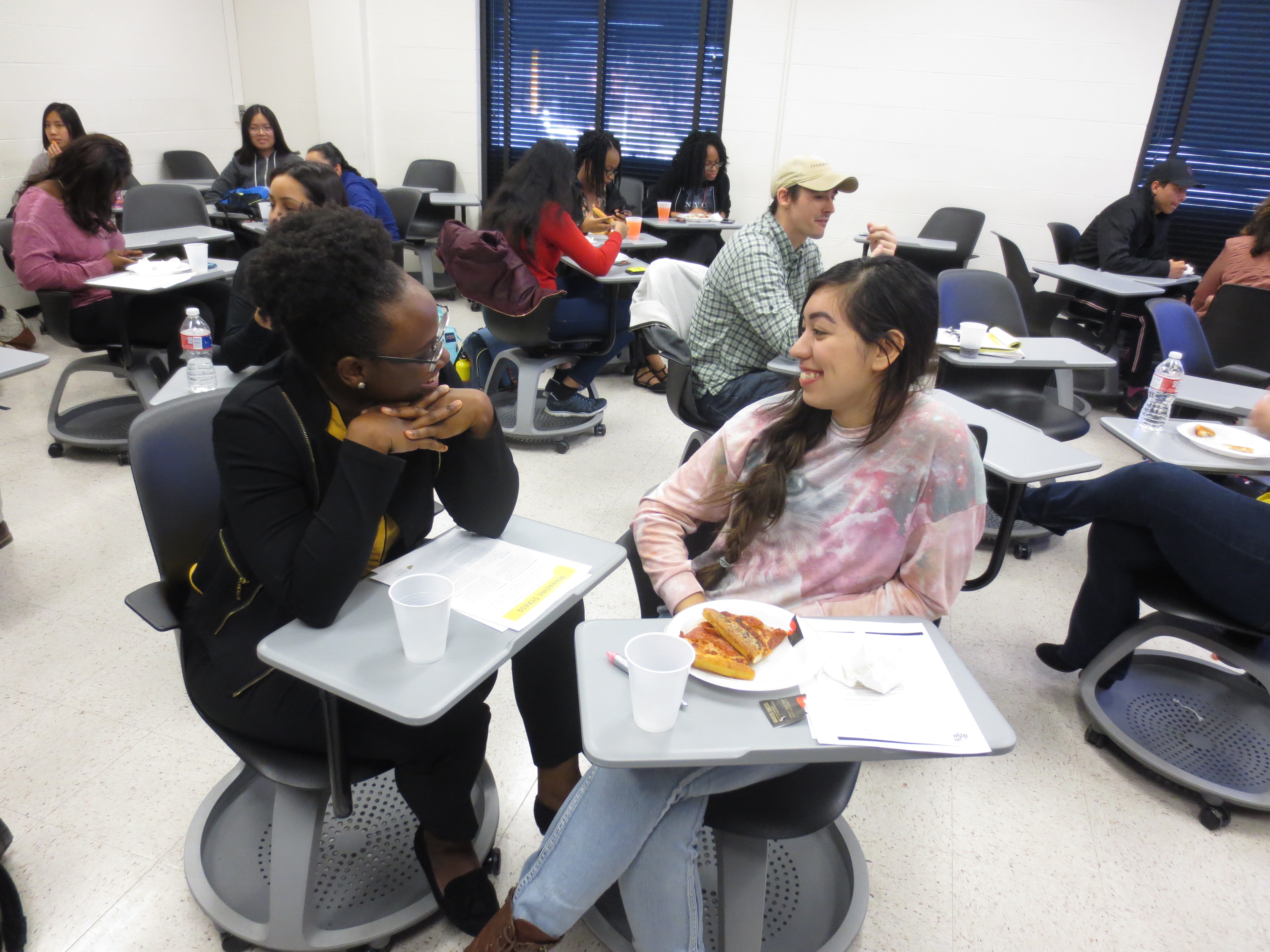 Two students chat in a classroom