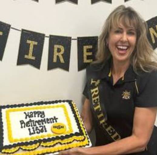 Lisa Wiebe smiles next to her retirement cake. 