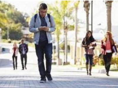 Man walking while looking at his phone