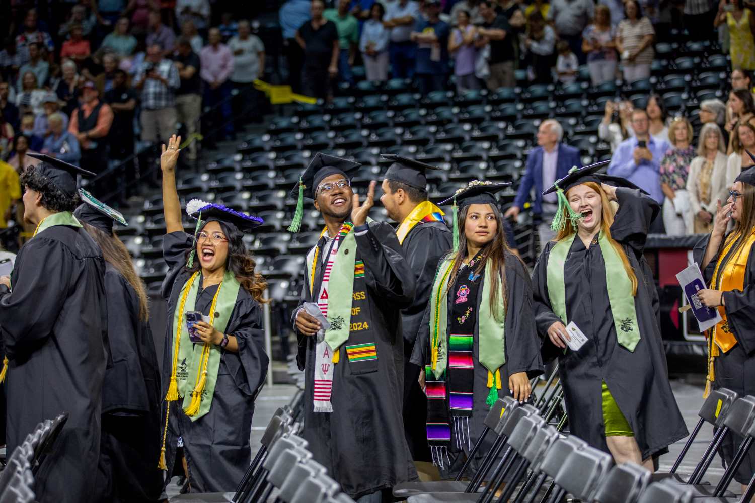 Students waving to crowd at Commencement