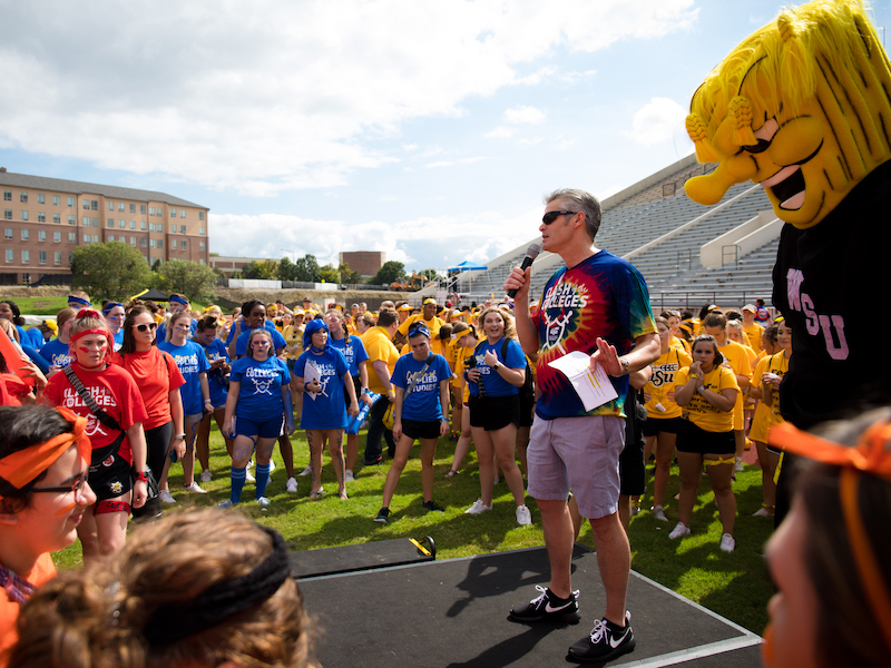 Photo of President Rick Muma speaking to the Clash of the Colleges teams. 