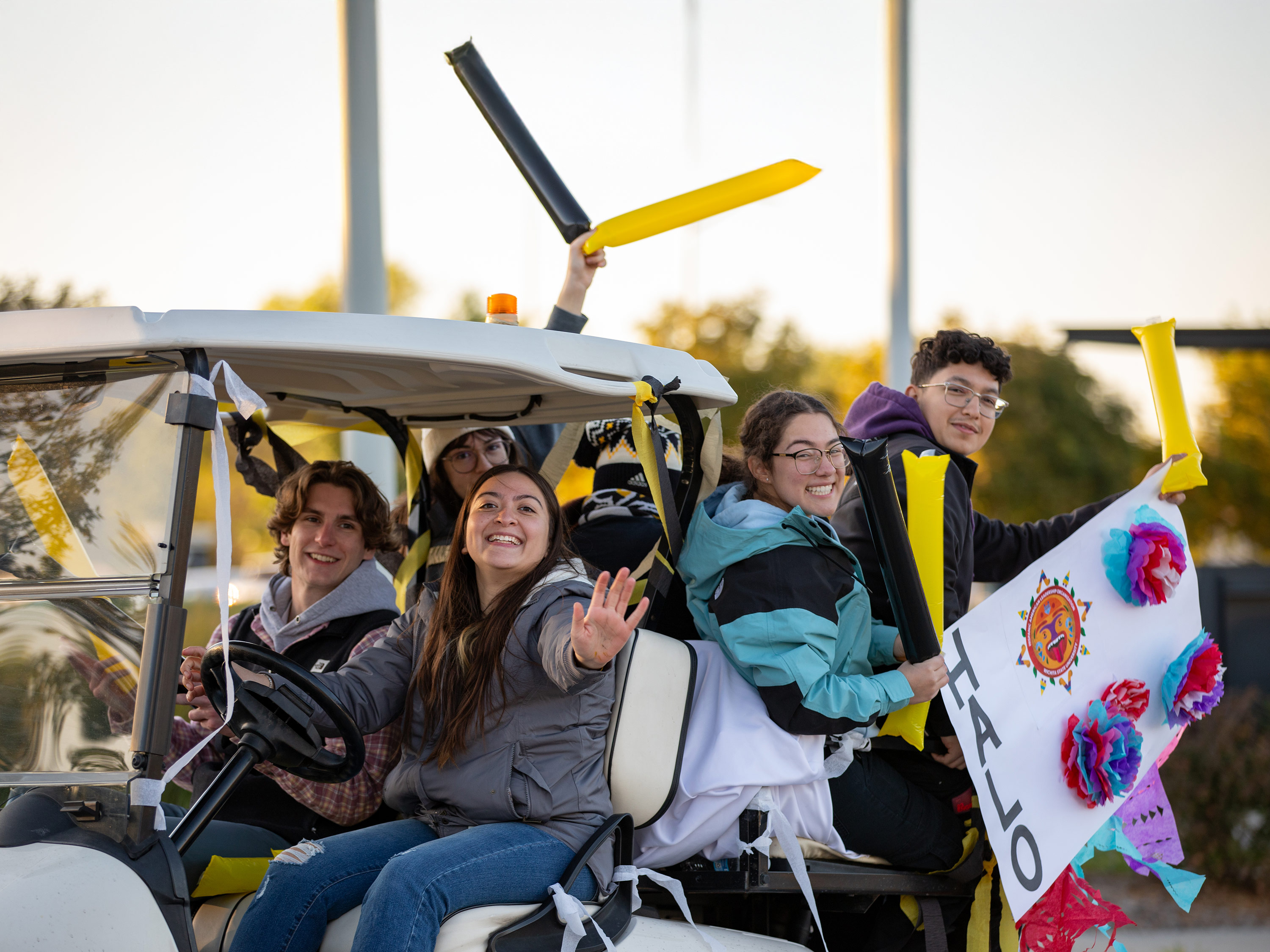 Students ride a golf cart at the Shocktoberfest parade.