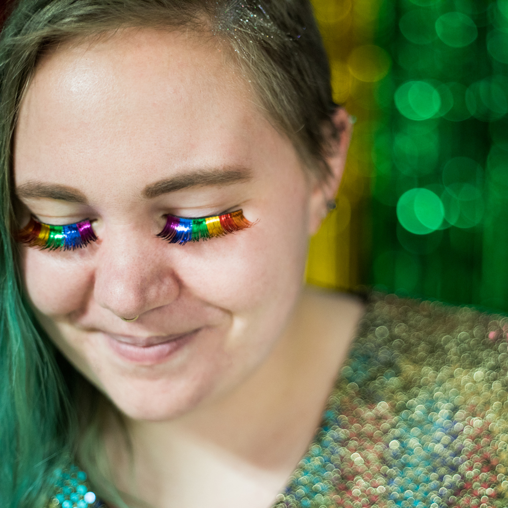 Female student wearing rainbow eyelashes at Pride Prom.