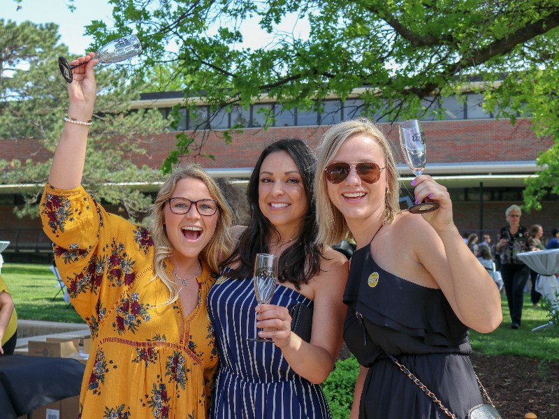 Graduates posing with their champagne flute