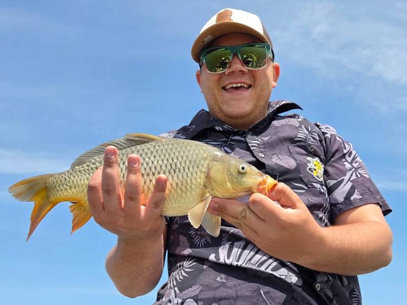 Man holding carp and smiling