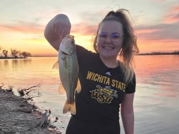 Girl in WSU shirt holding fish. 