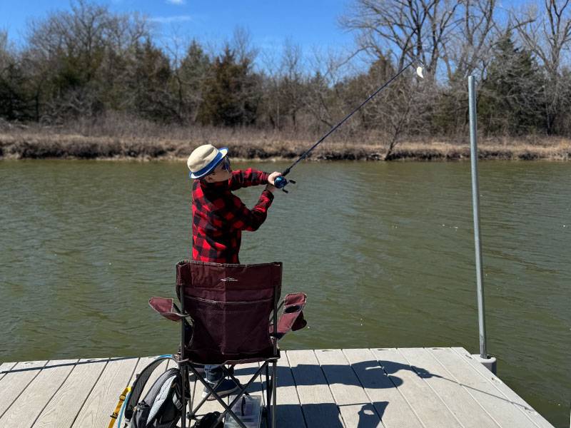 a young boy casts a line off a dock