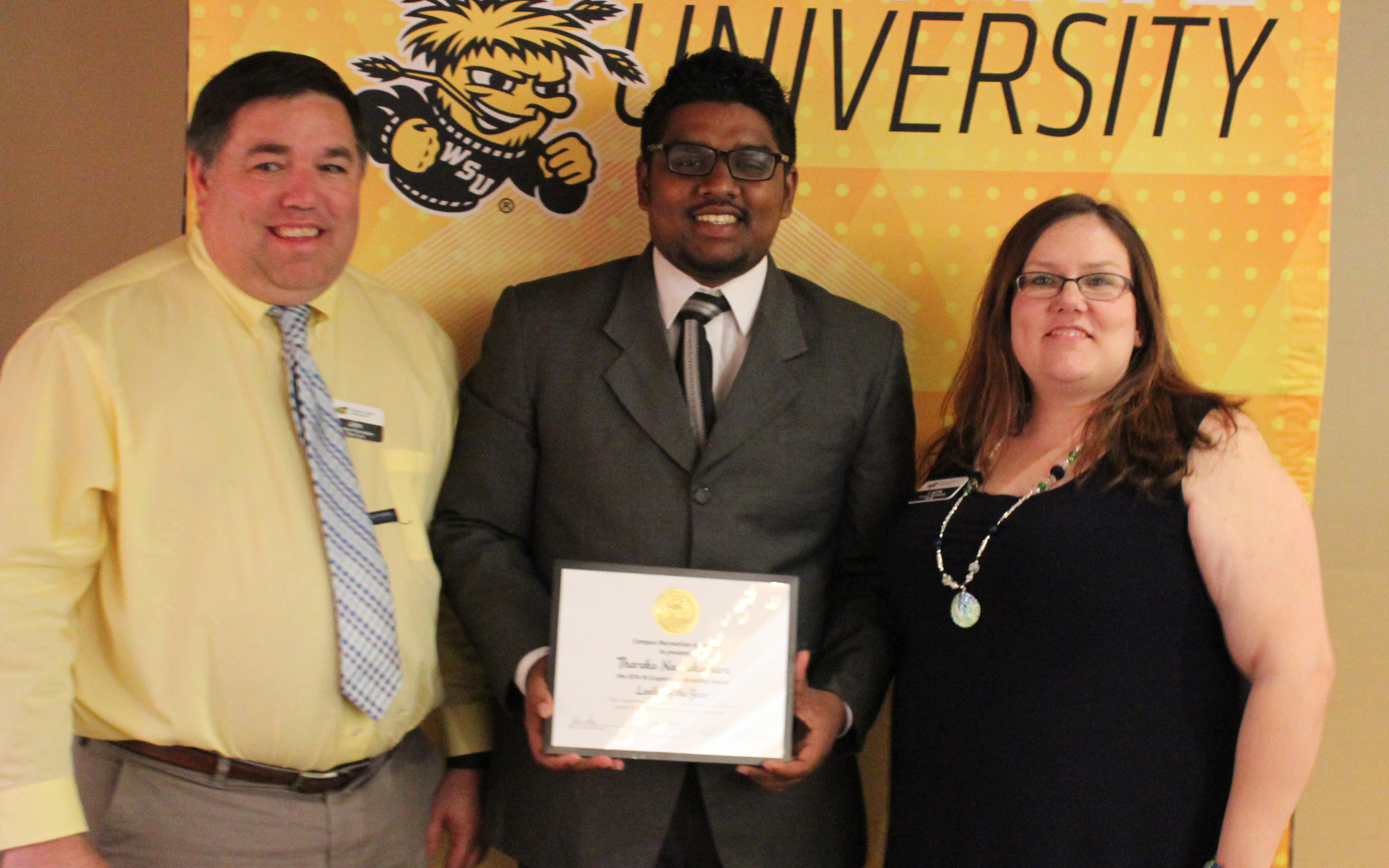 Three people with award