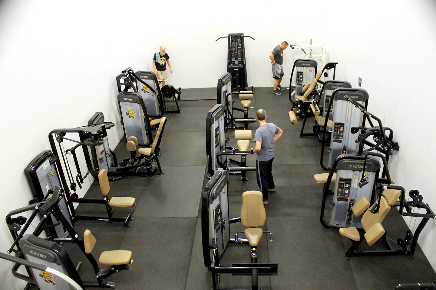 view of the circut room, a room with various exersize equipment on a gym type floor, from a high view. Theres like. Three guys.