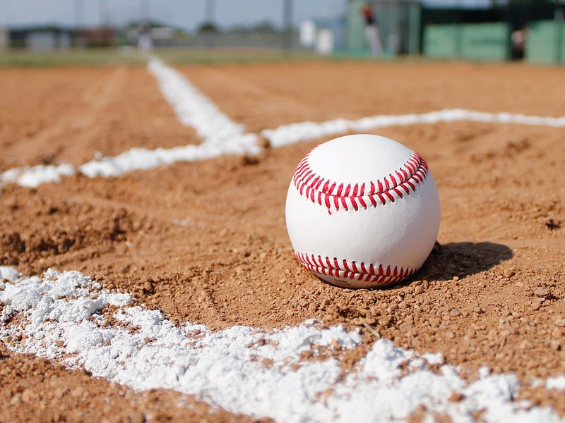 Baseball in dirt of a baseball diamond