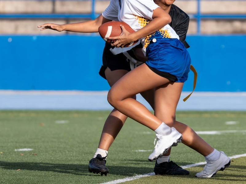 two students on a field playing flag football