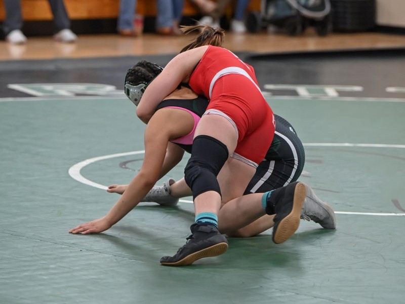 two students wrestling on a mat