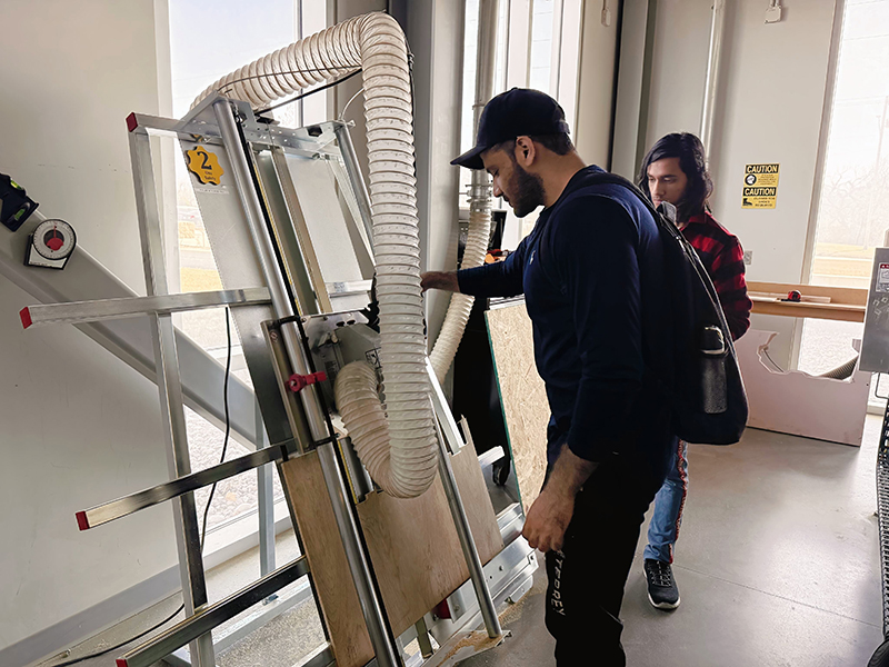 Abbas Minhal uses a vertical panel saw during a woodworking workshop at the Prairie Innovation Hub woodshop.