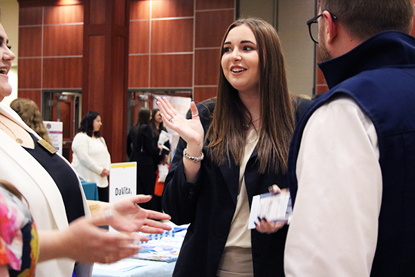 Taylor Southern speaking with employers at a career fair.