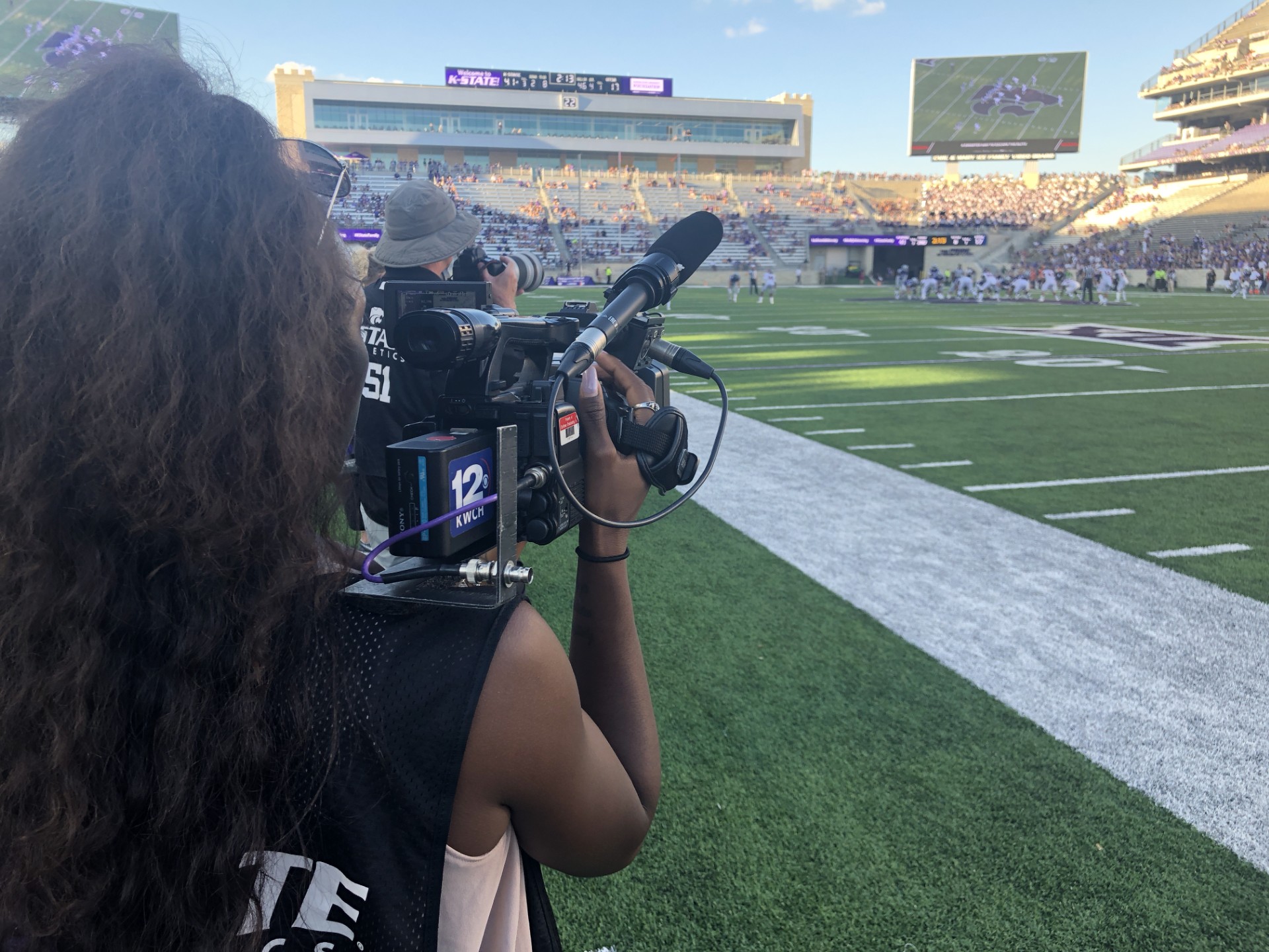 Image of Daysha Bullocks manning a camera for KWCH 12 at a K-State football game.