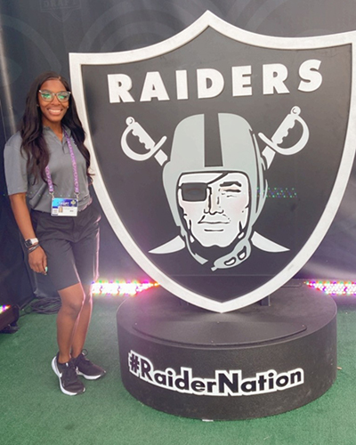 Daysha Bullocks stands with Raiders' memorabilia