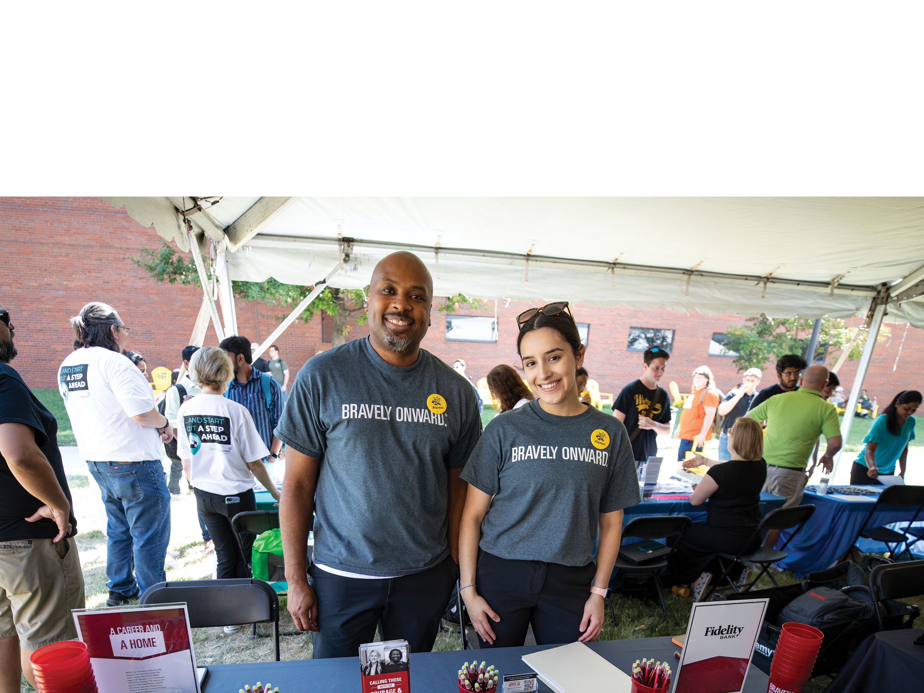 Image of Fidelity Bank employers smiling at the camera while tabling at the Kegger.