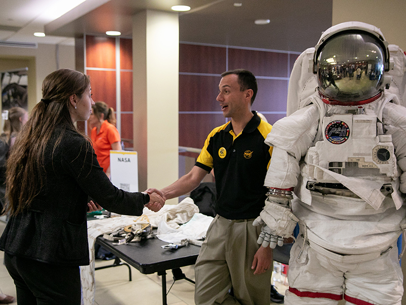 Student talks to NASA employee at the engineering and IT career fair.