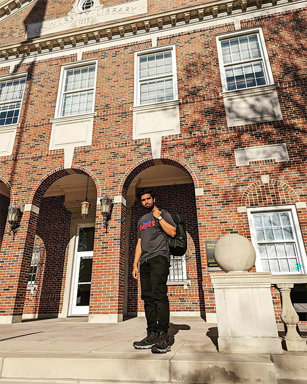 Golam Morshed Khan standing in front of a library