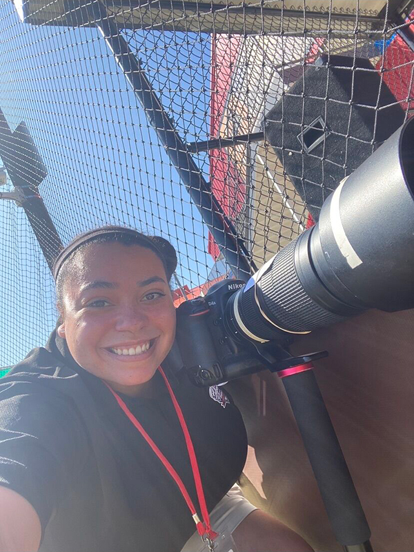 Amaya Harris holds a camera at the ballfield.