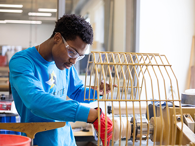 Student worker using machinery at GoCreate.
