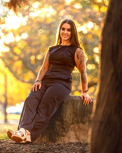 Bella Neish sitting on a rock.