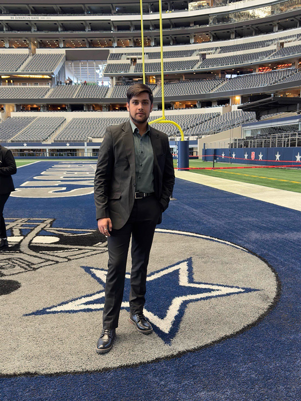 Akash Pandey stands on the Dallas Cowboys football field