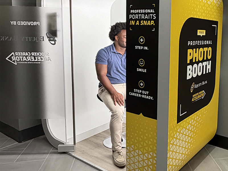 Wichita State student using the Shocker Career Accelerator photo booth to take professional headshots.