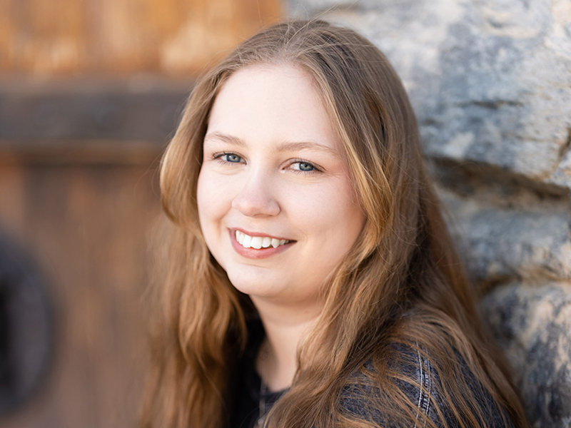 Image of a female student leaning against a wall.