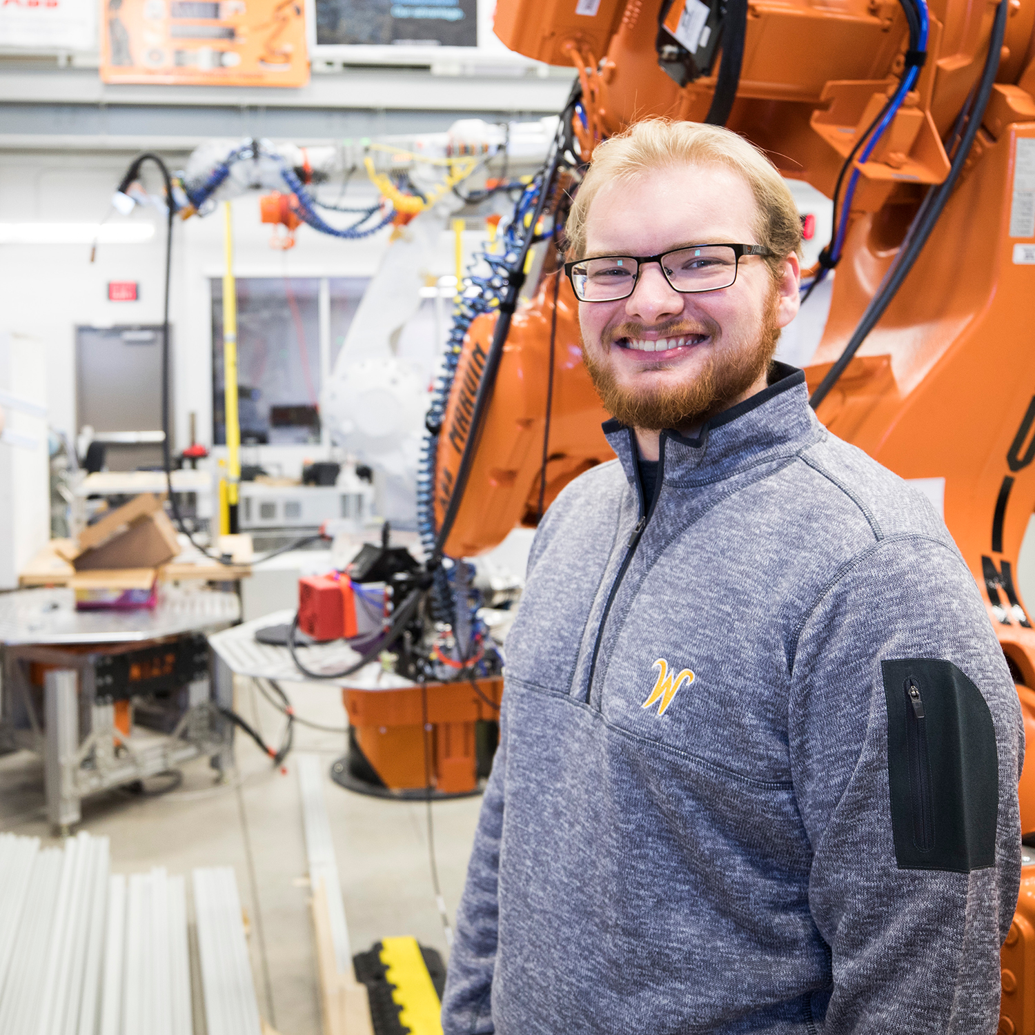 Photo of a man standing in front of a large robotic machine