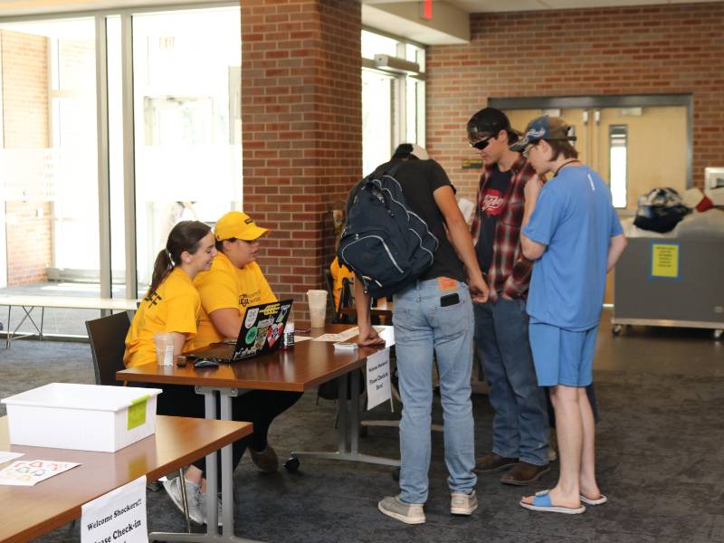students checking in to desk