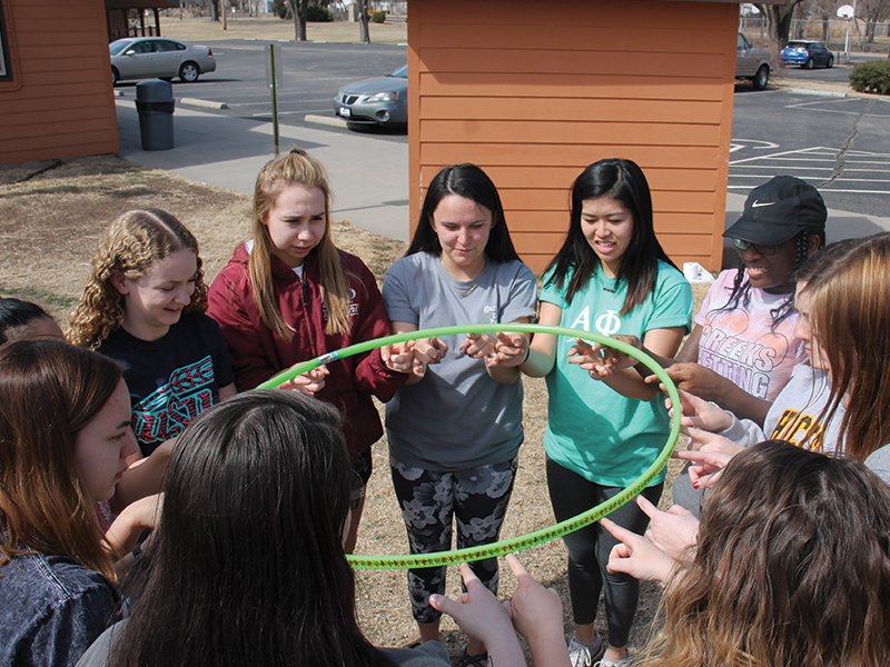 A group of students participating in a hula hoop activity
