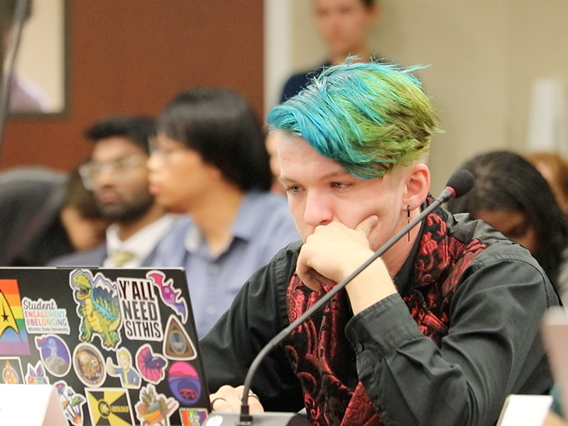 SGA student looking at his computer during a senate meeting.