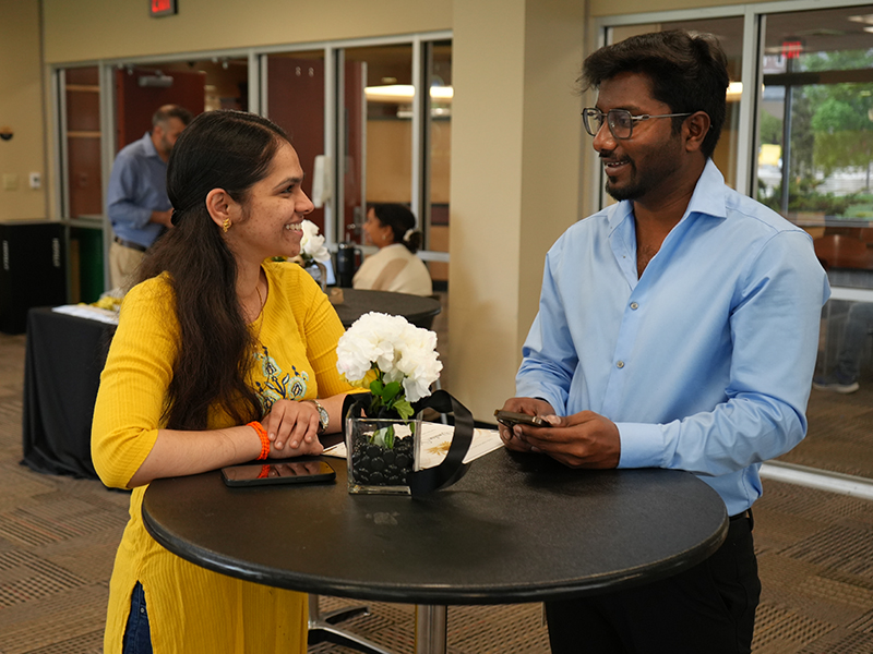 Two students engaging in conversation during Academic Excellence celebration.