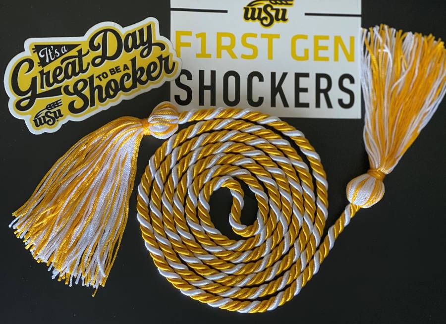 photo of a graduation cord and a sticker that says "F1RST GEN SHOCKERS" and "it's a great day to be a Shocker"
