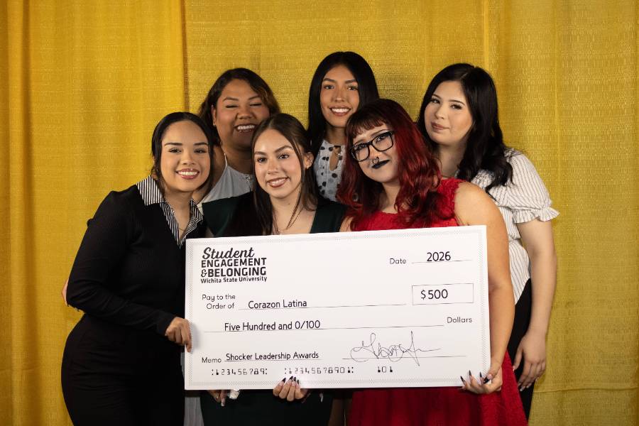Corozan Latina holding a check from Shocker Leadership Awards