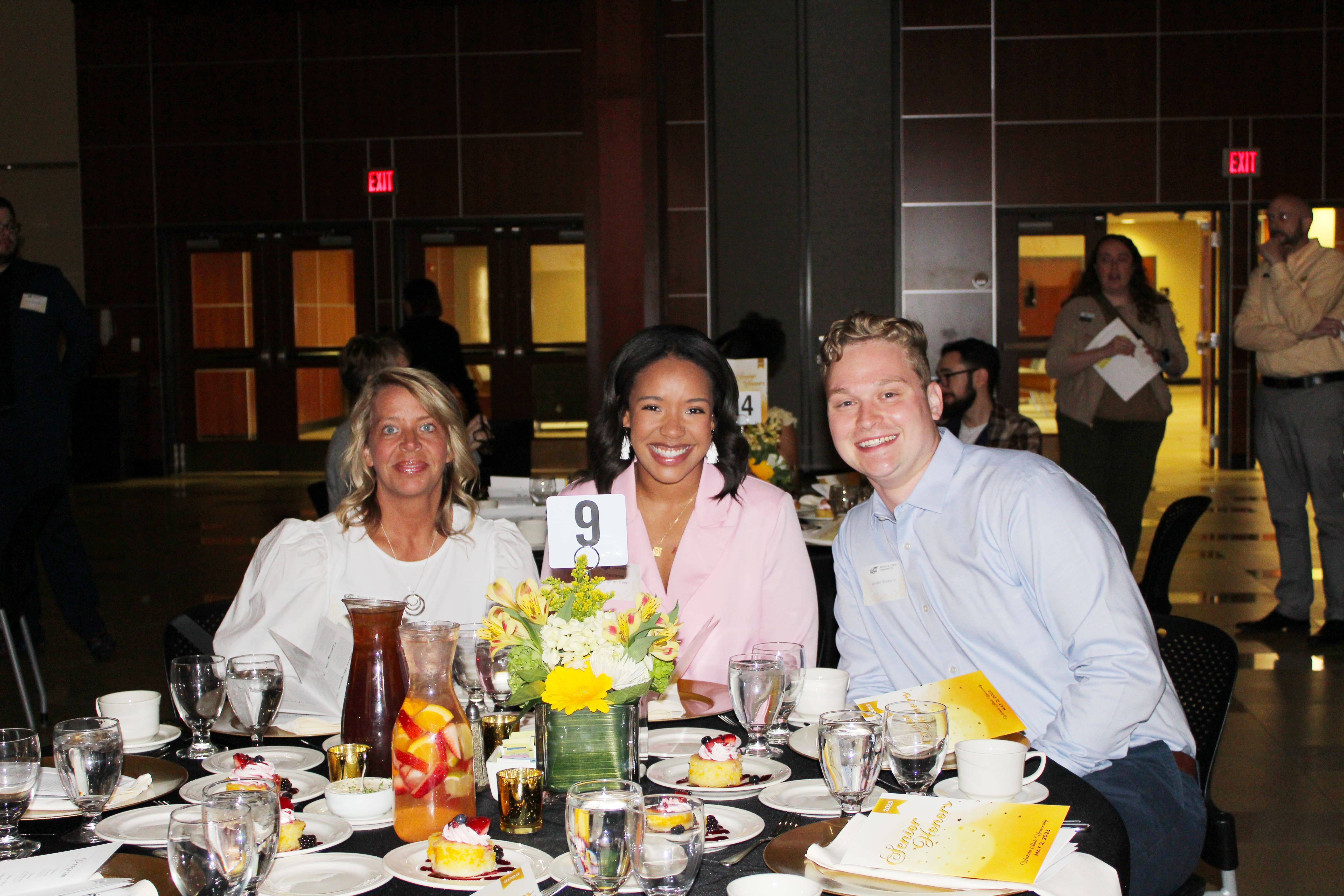 Guests smile for the camera as they eat their dinner