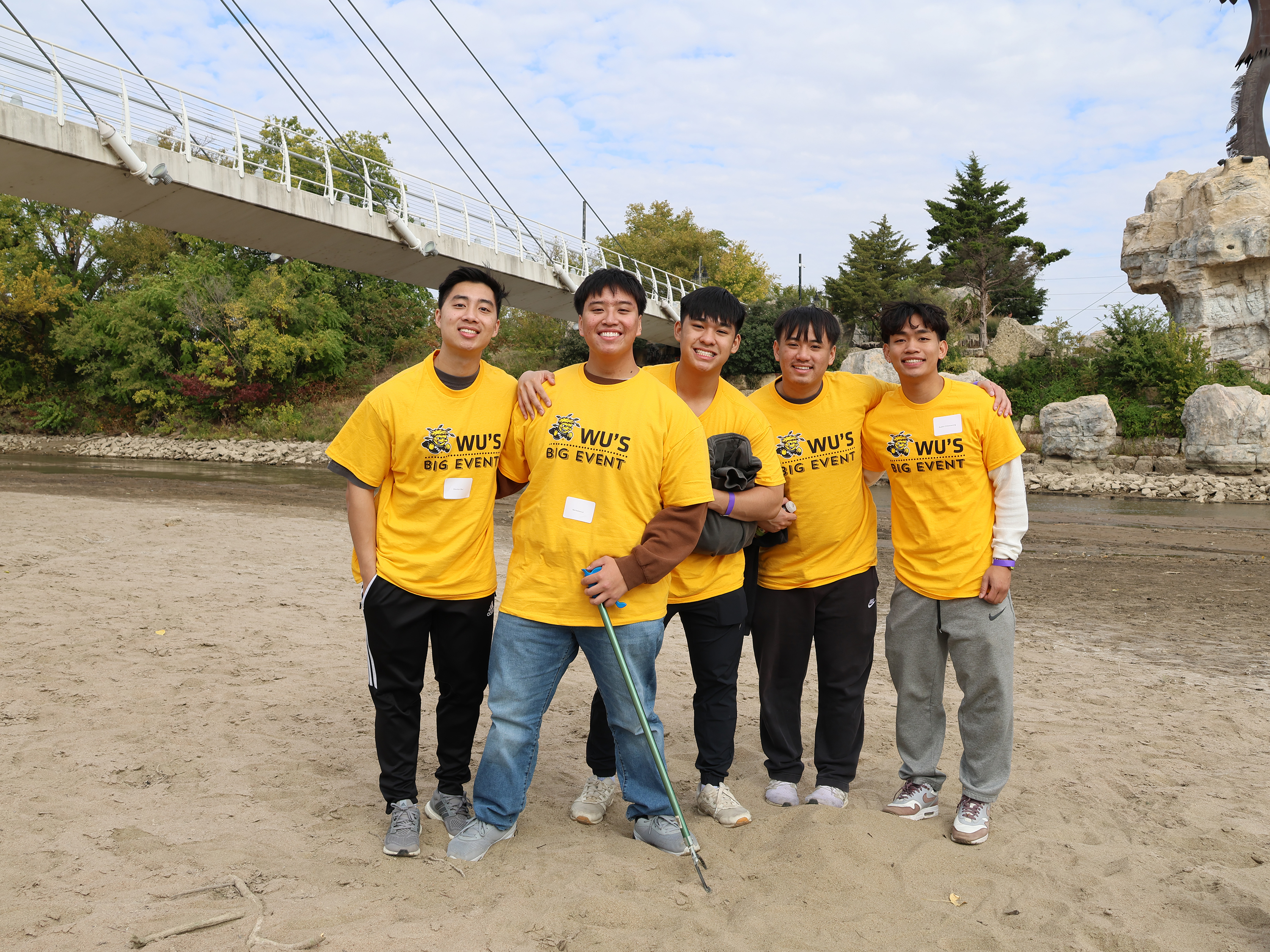 Group of students posing for the camera during Wu's Big Event. Cleaning up the river in downtown Wichita.