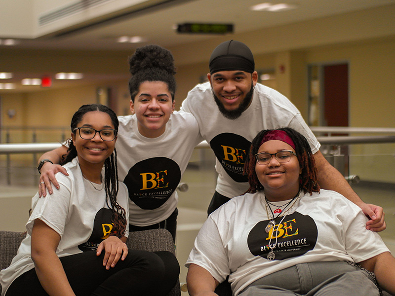 Group of students wearing Black Excellence shirts posing for the camera