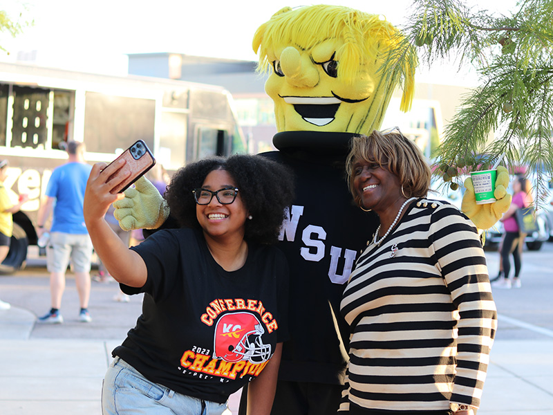 A student and her mom taking a selfie with WuShock at the patio party