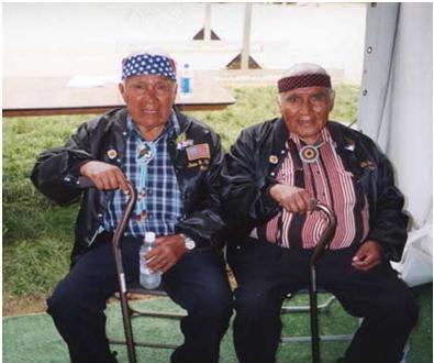 Two elderly Native American veterains sitting in folding chairs