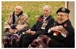 Three elderly veterains in wheelchairs