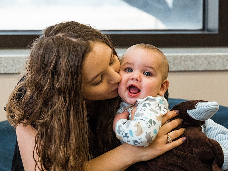 A military-connected student snuggling a baby.