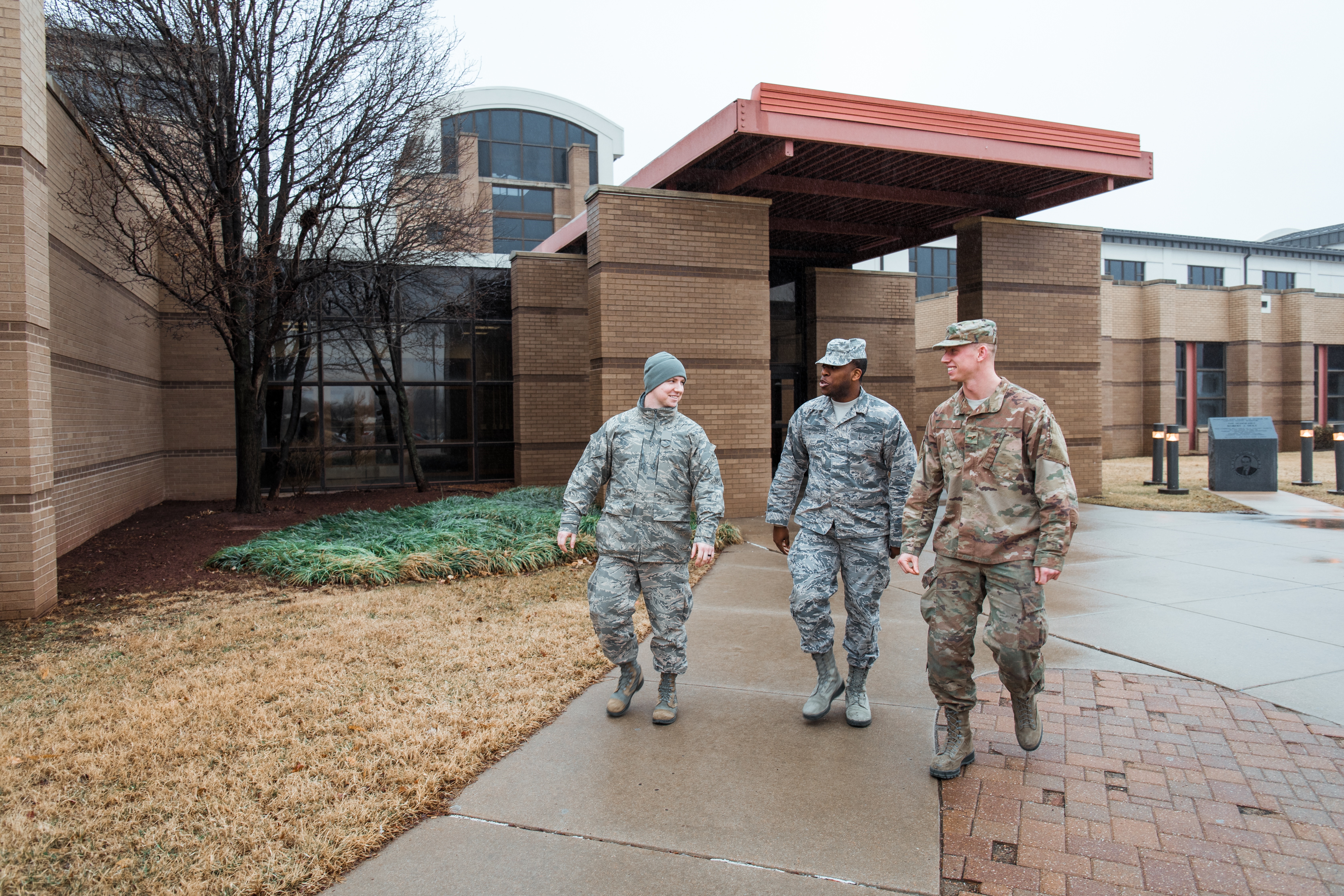 Three people in uniform walk outside at McConnell Air Force Base.